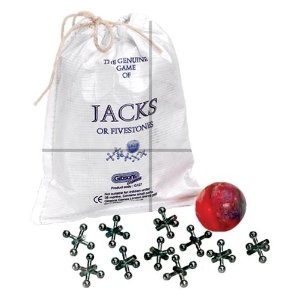 Detail of hands playing the game of jacks with metal jacks and a small bouncing ball on a playground floor.